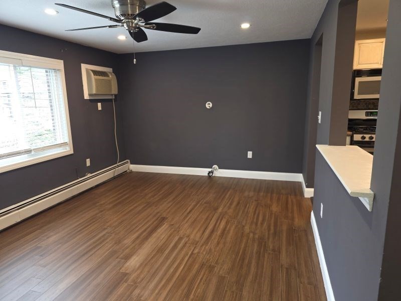70 Mudge Street, Unit 12 Lynn, MA 01902 - Photo 8 of 22 an empty room with wooden floor and windows