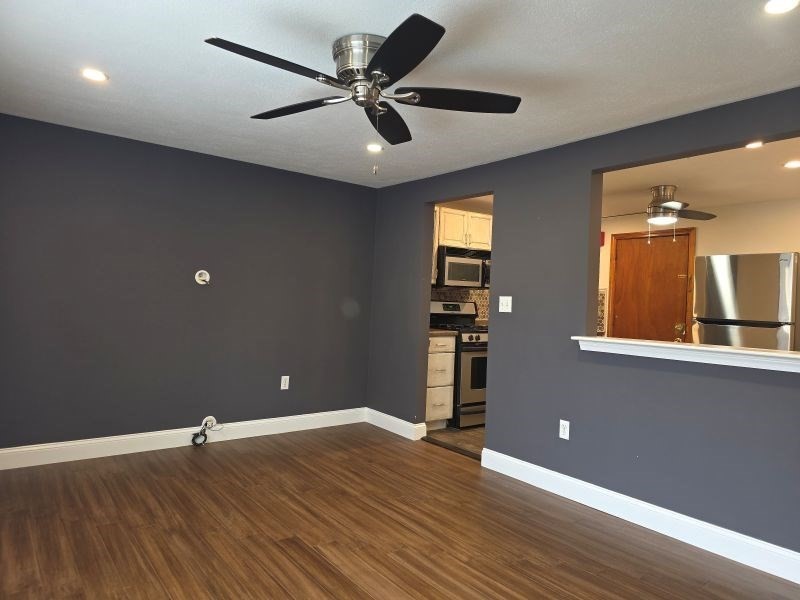 70 Mudge Street, Unit 12 Lynn, MA 01902 - Photo 9 of 22 a view of a livingroom with a ceiling fan and wooden floor
