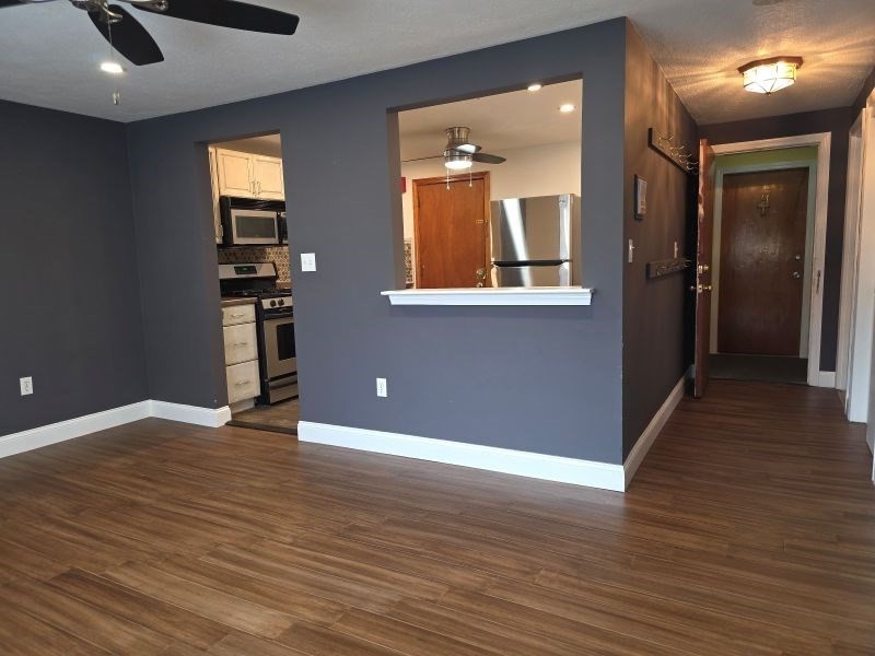 70 Mudge Street, Unit 12 Lynn, MA 01902 - Photo 10 of 22 an empty room with wooden floor and windows