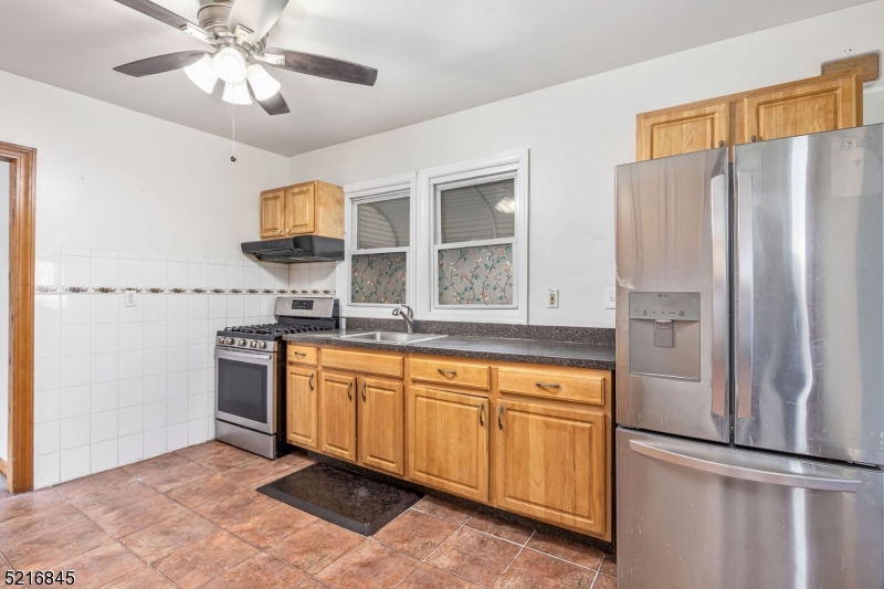 213 Linden Road, Unit 213 Roselle, NJ 07203 - Photo 11 of 14 a kitchen with stainless steel appliances granite countertop a refrigerator a sink and white cabinets