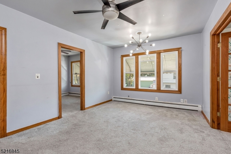 213 Linden Road, Unit 213 Roselle, NJ 07203 - Photo 2 of 14 an empty room with chandelier fan and windows
