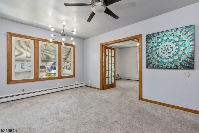 213 Linden Road, Unit 213 Roselle, NJ 07203 - Photo 3 of 14 an empty room with chandelier fan and windows