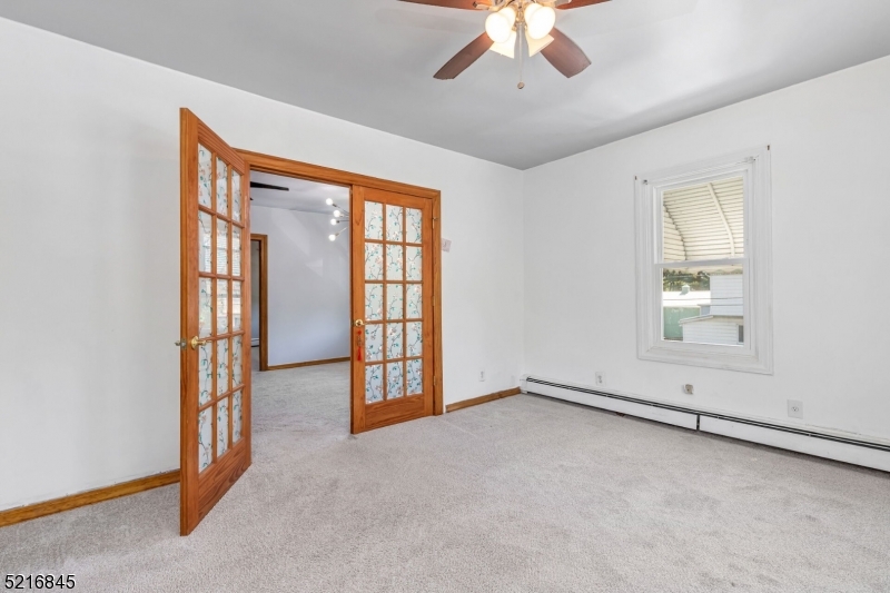 213 Linden Road, Unit 213 Roselle, NJ 07203 - Photo 6 of 14 an empty room with chandelier fan and windows