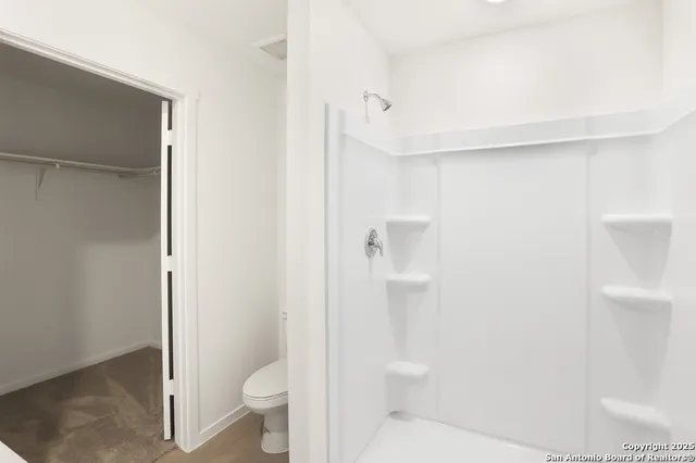 a bathroom with a toilet and a shower