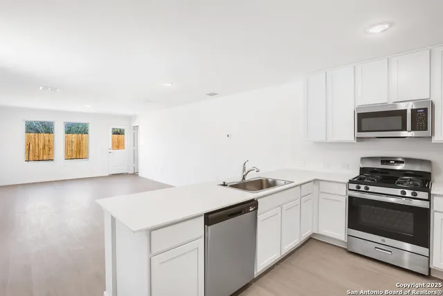 a kitchen with a sink stove and microwave