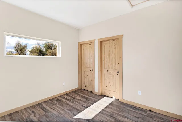 a view of an empty room with wooden floor