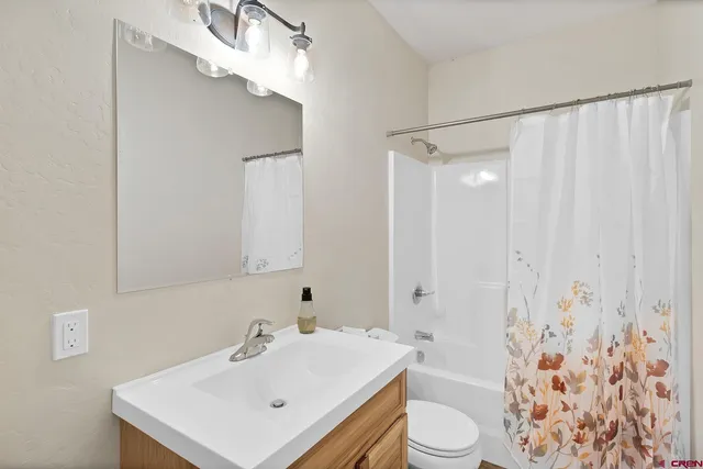 a bathroom with a sink a toilet and shower curtain