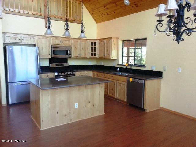 3238 Lodgepole Road Overgaard, AZ 85933 - Photo 3 of 7 a kitchen with stainless steel appliances granite countertop a sink a stove and a wooden floors