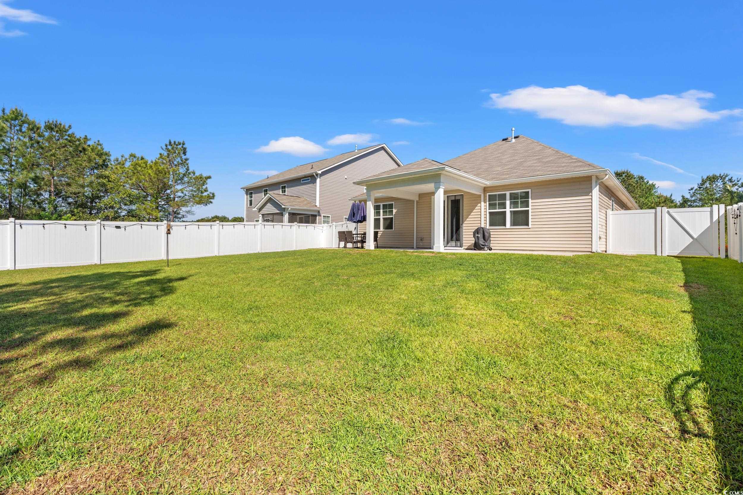1087 Baker Creek Loop Myrtle Beach, SC 29579 - Photo 27 of 37 Rear view of house featuring a lawn and a fenced b