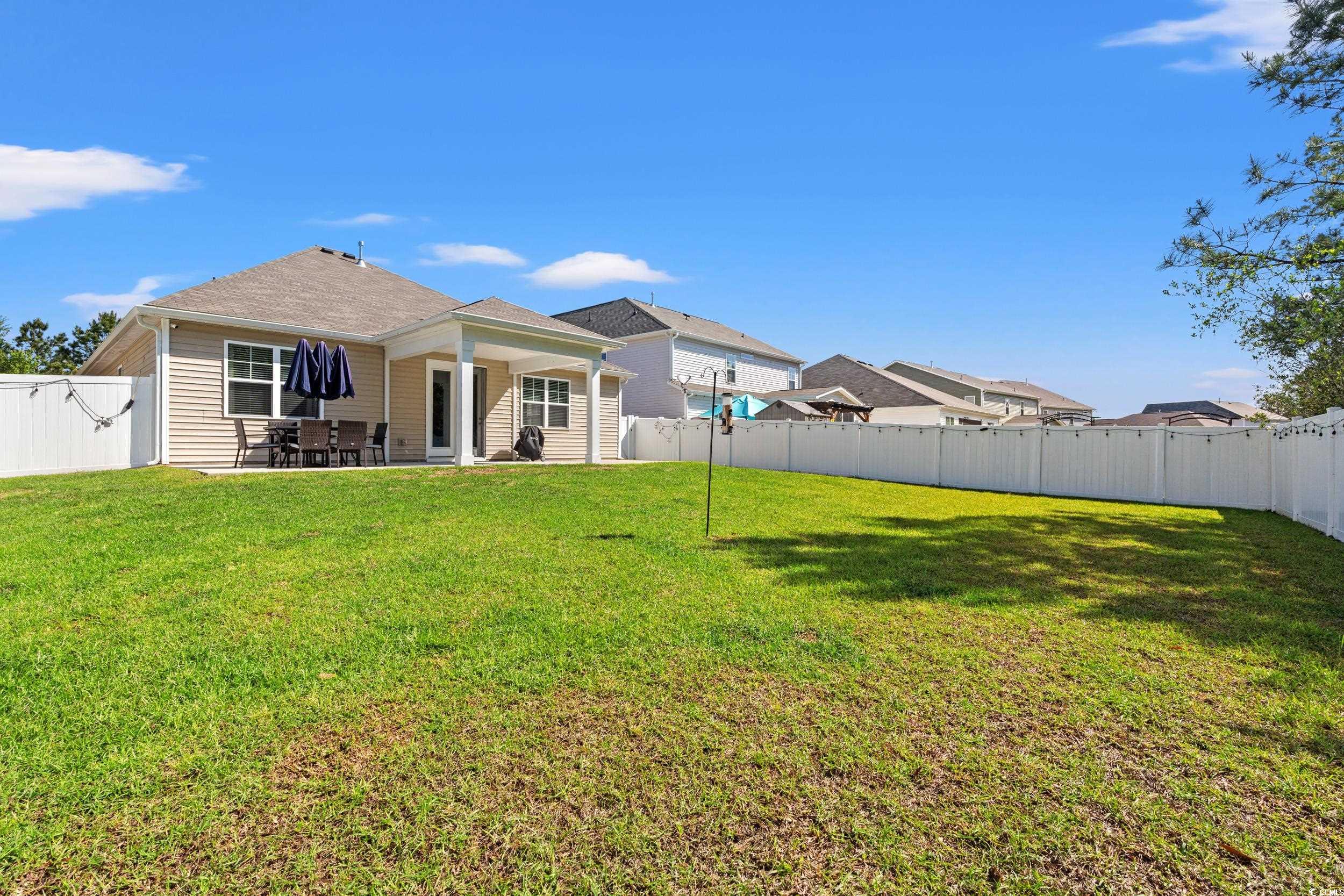 1087 Baker Creek Loop Myrtle Beach, SC 29579 - Photo 28 of 37 Rear view of house featuring a lawn, a patio area,