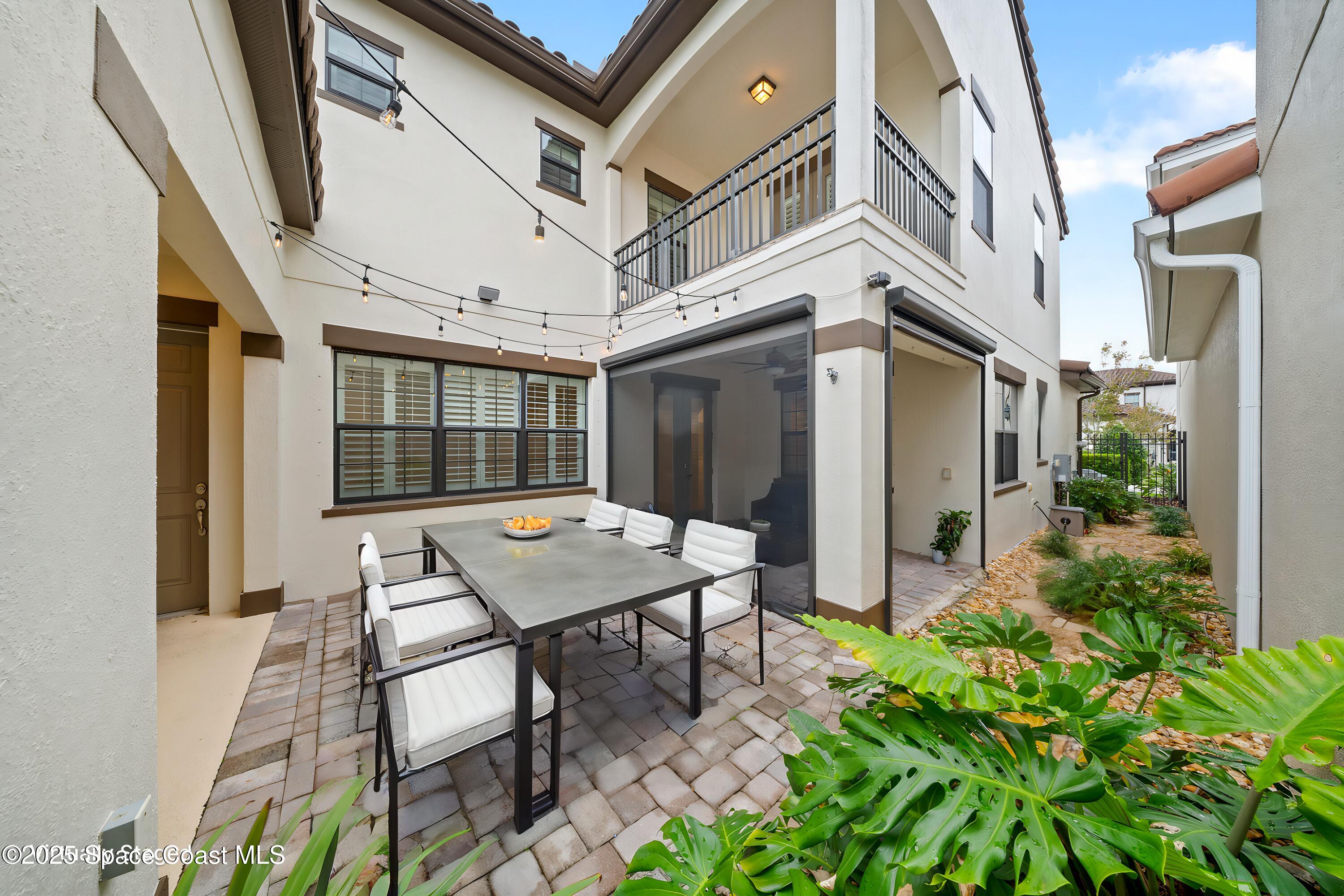 a view of a patio with table and chairs and potted plants