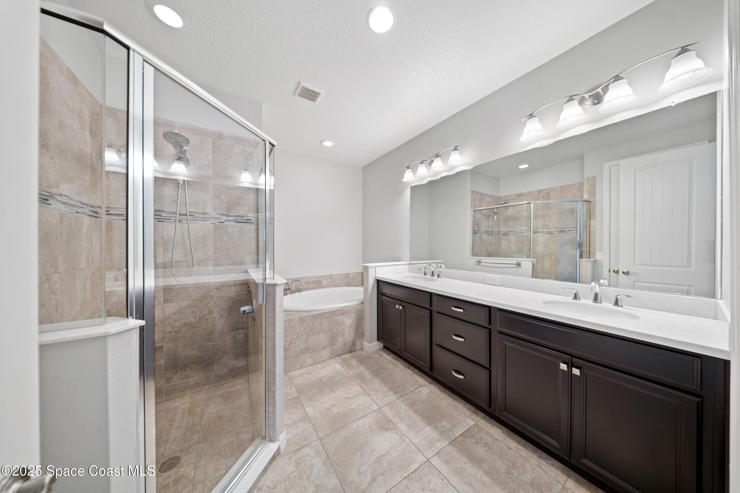 8830 Napolo Drive Melbourne, FL 32940 - Photo 17 of 36 a bathroom with a double vanity sink mirror and shower