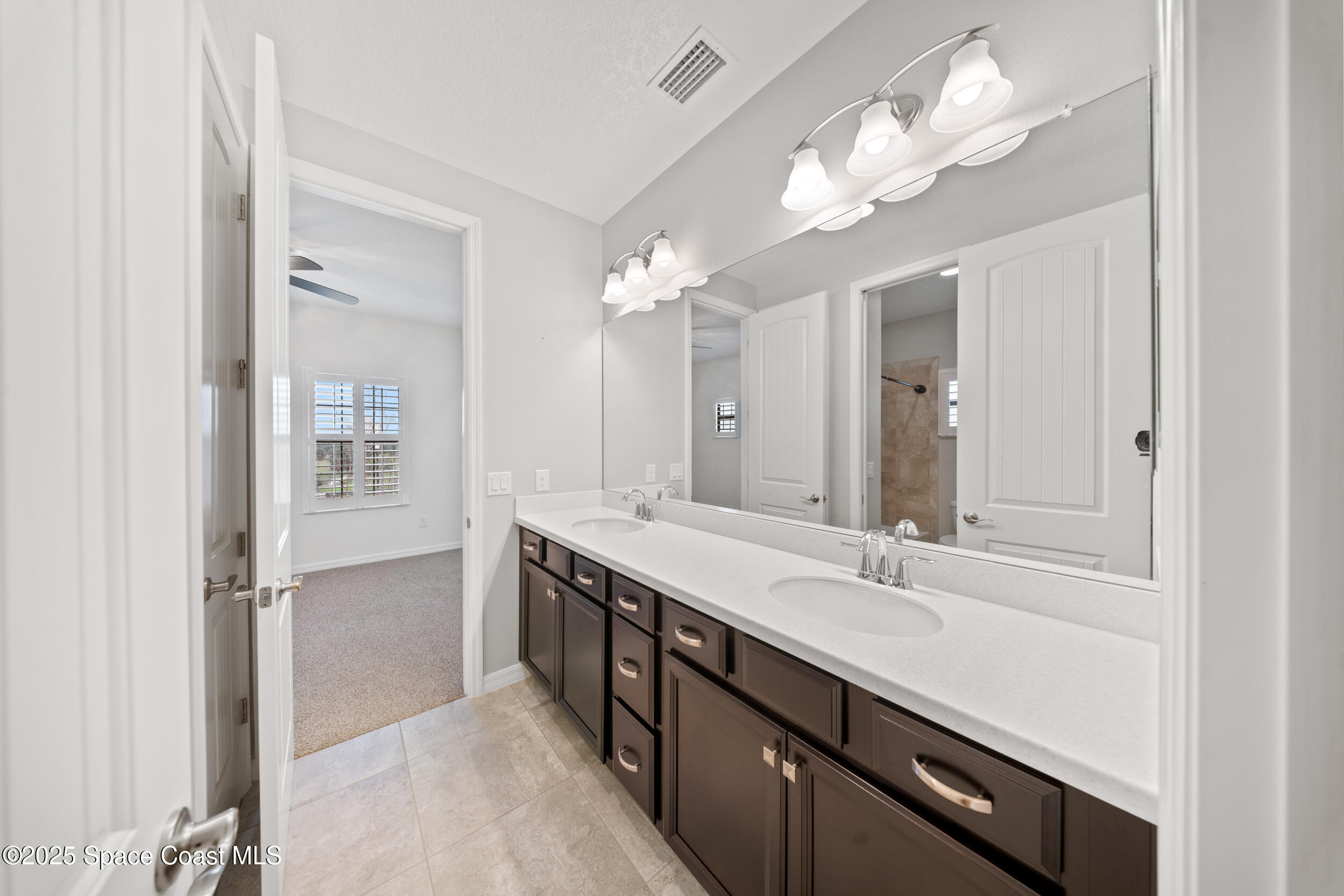 8830 Napolo Drive Melbourne, FL 32940 - Photo 21 of 36 a bathroom with a double vanity sink and a mirror