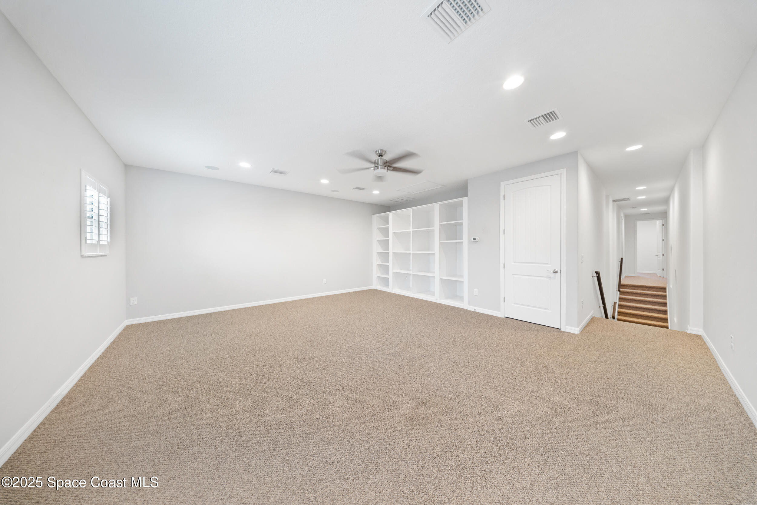 8830 Napolo Drive Melbourne, FL 32940 - Photo 24 of 36 an empty room with windows and ceiling fan