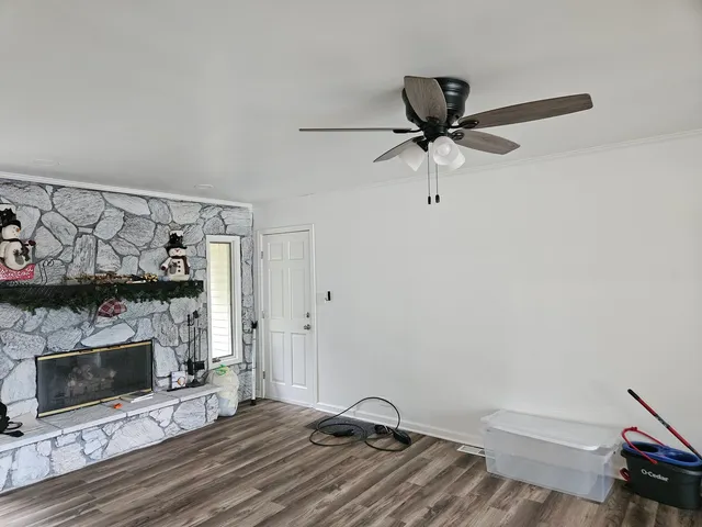 a view of a livingroom with a fireplace and a ceiling fan