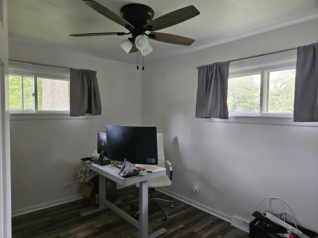 a view of a workspace with furniture and a window