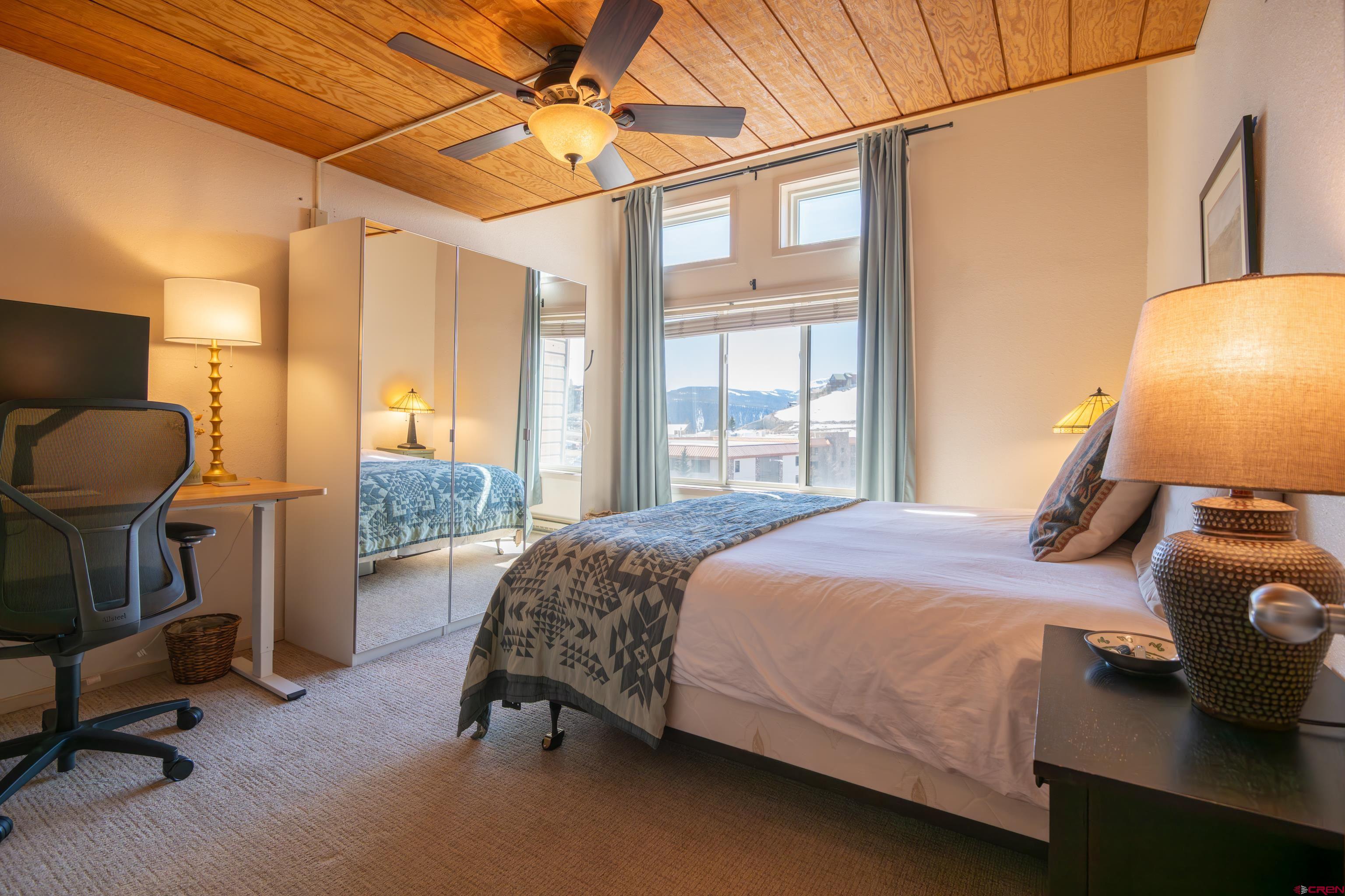 25 Emmons Road, Unit 41 Crested Butte, CO 81225 - Photo 16 of 45 a bedroom with a bed and a chandelier