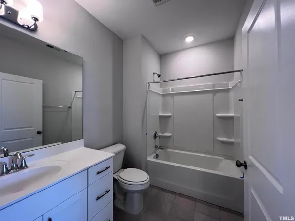a bathroom with a bathtub shower sink vanity and toilet