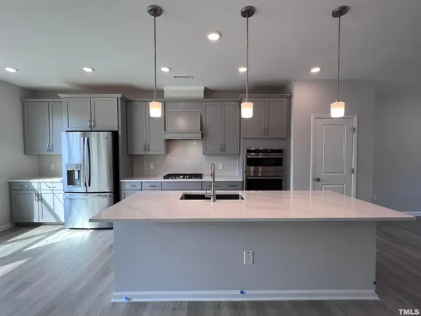 a large kitchen with kitchen island a sink stainless steel appliances and cabinets