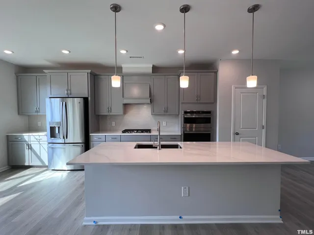 a large kitchen with kitchen island a sink stainless steel appliances and cabinets