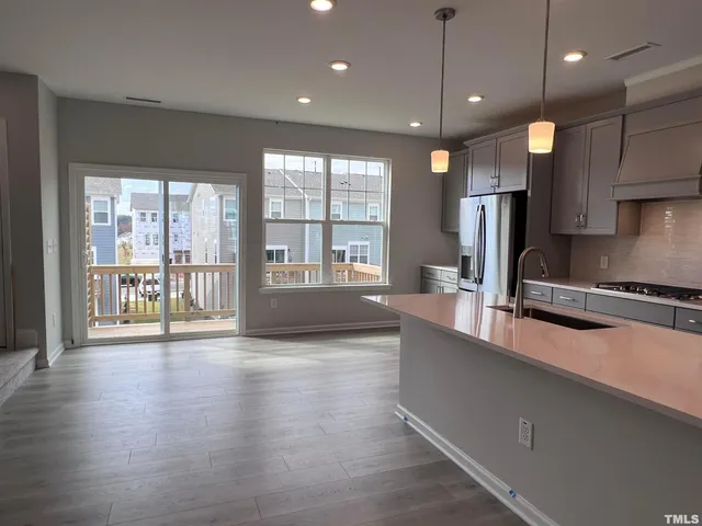 a large kitchen with kitchen island a large counter space a sink appliances and cabinets