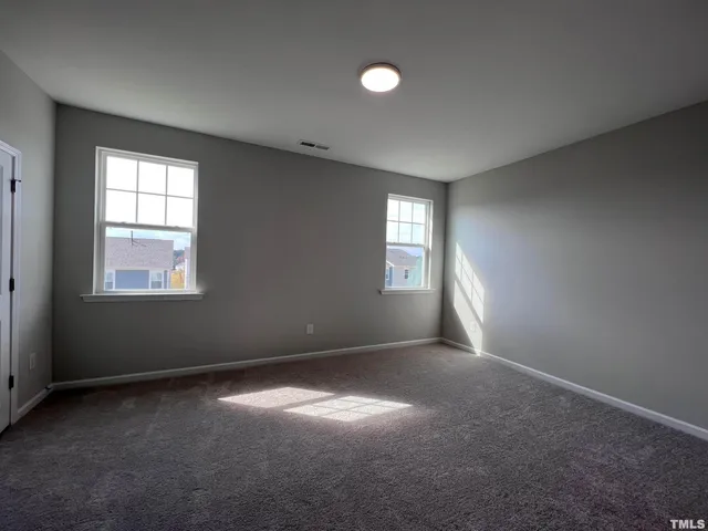 an empty room with windows and closet
