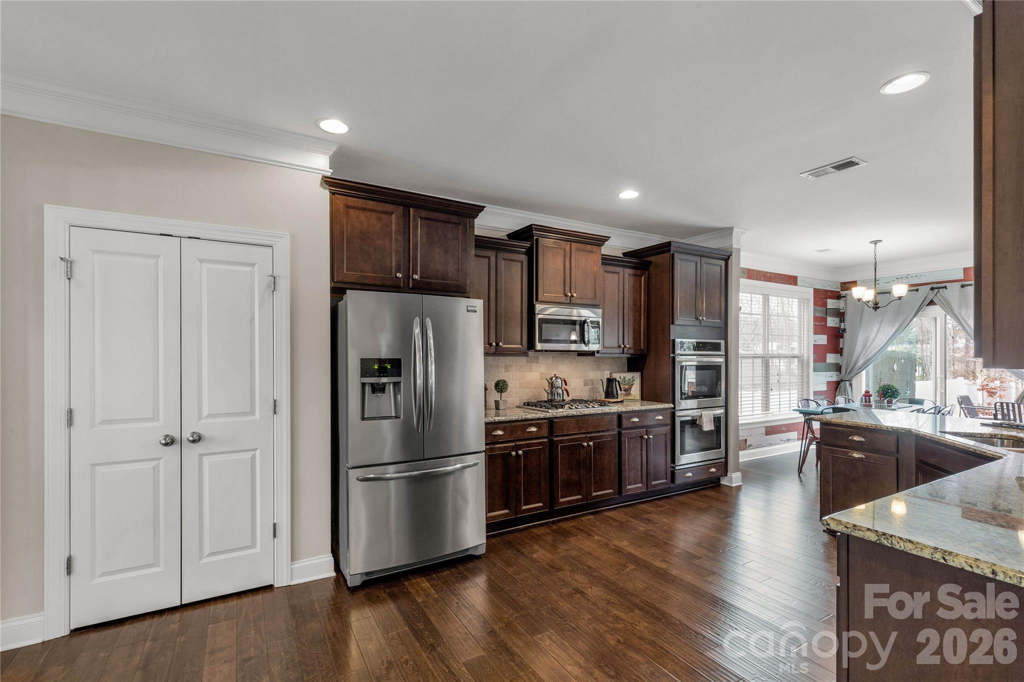 1372 Rainier Drive Fort Mill, SC 29708 - Photo 9 of 48 a kitchen with stainless steel appliances granite countertop a refrigerator a sink dishwasher a stove and a refrigerator with wooden floor