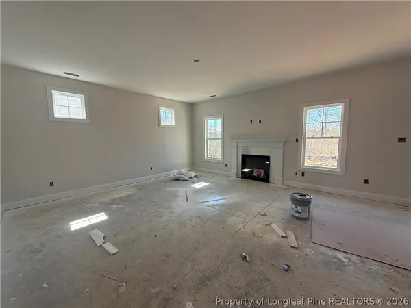 an empty room with fireplace and window