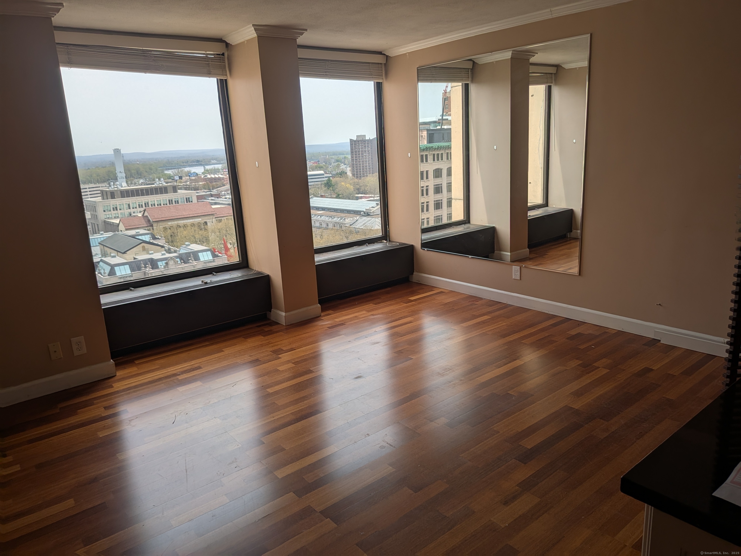 1 Gold Street, Unit 16F Hartford, CT 06103 - Photo 2 of 20 a view of an empty room with wooden floor and a window