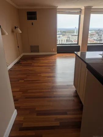 a view of hallway with window and wooden floor