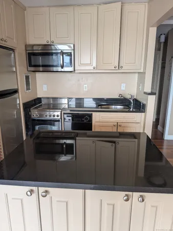 a kitchen with stainless steel appliances granite countertop a stove and a microwave