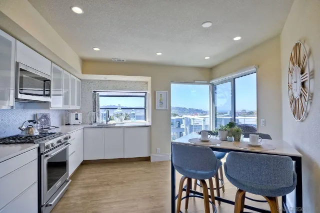 a kitchen with stainless steel appliances granite countertop a stove a sink dishwasher and a refrigerator with wooden floor