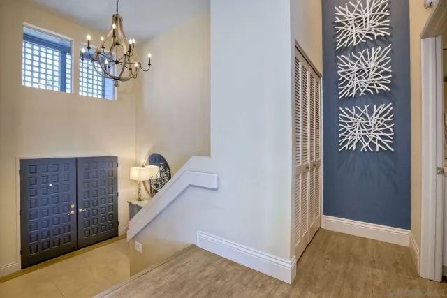 a view of a hallway with windows and chandelier