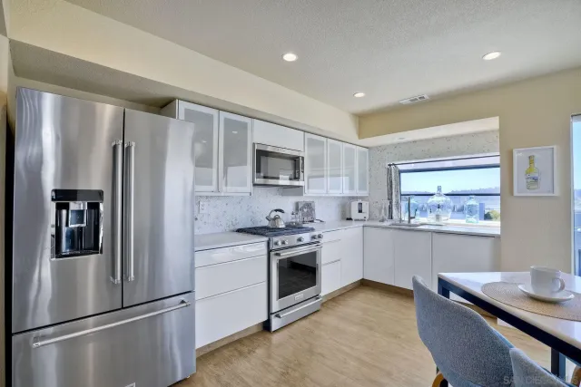 a kitchen with stainless steel appliances granite countertop a refrigerator sink and stove