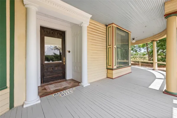 a view of front door and bedroom with wooden floor