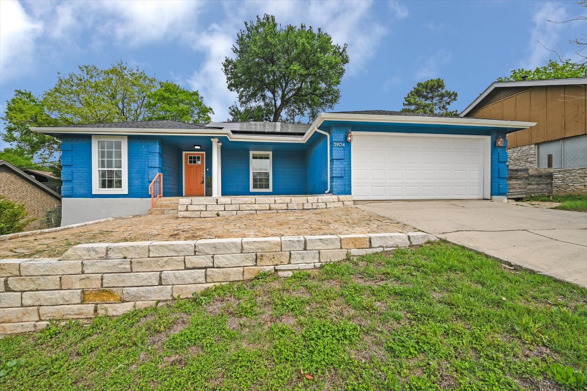 a front view of a house with a garden and plants