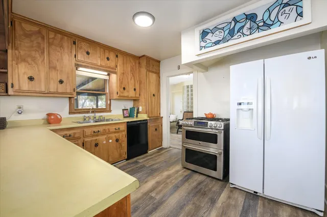 a kitchen with stainless steel appliances a stove a sink and a refrigerator
