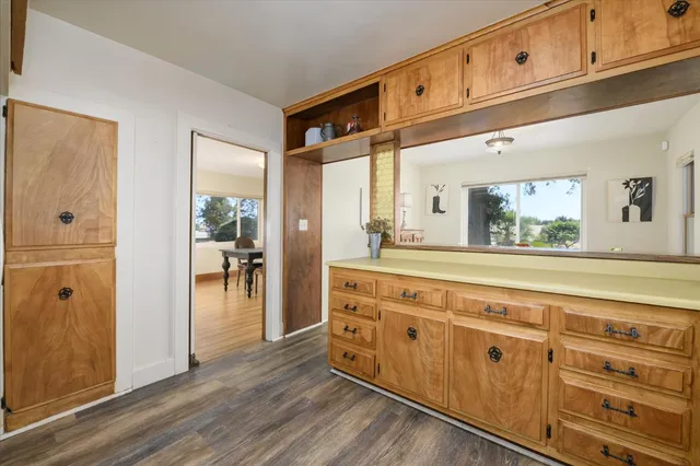 a view of a hallway with wooden floor and cabinet