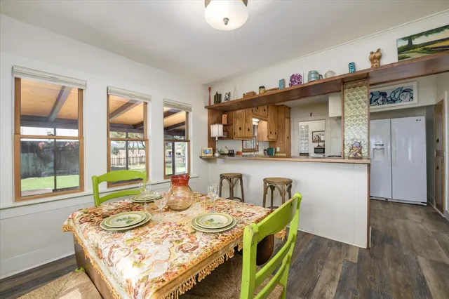 a living room with kitchen island a table and a large window