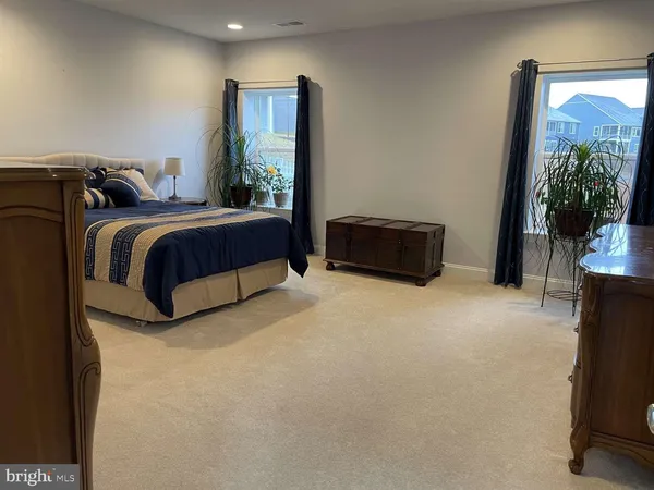 a spacious bedroom with a bed and a flat screen television