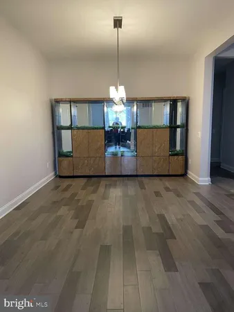 a view of a room with wooden floor and chandelier