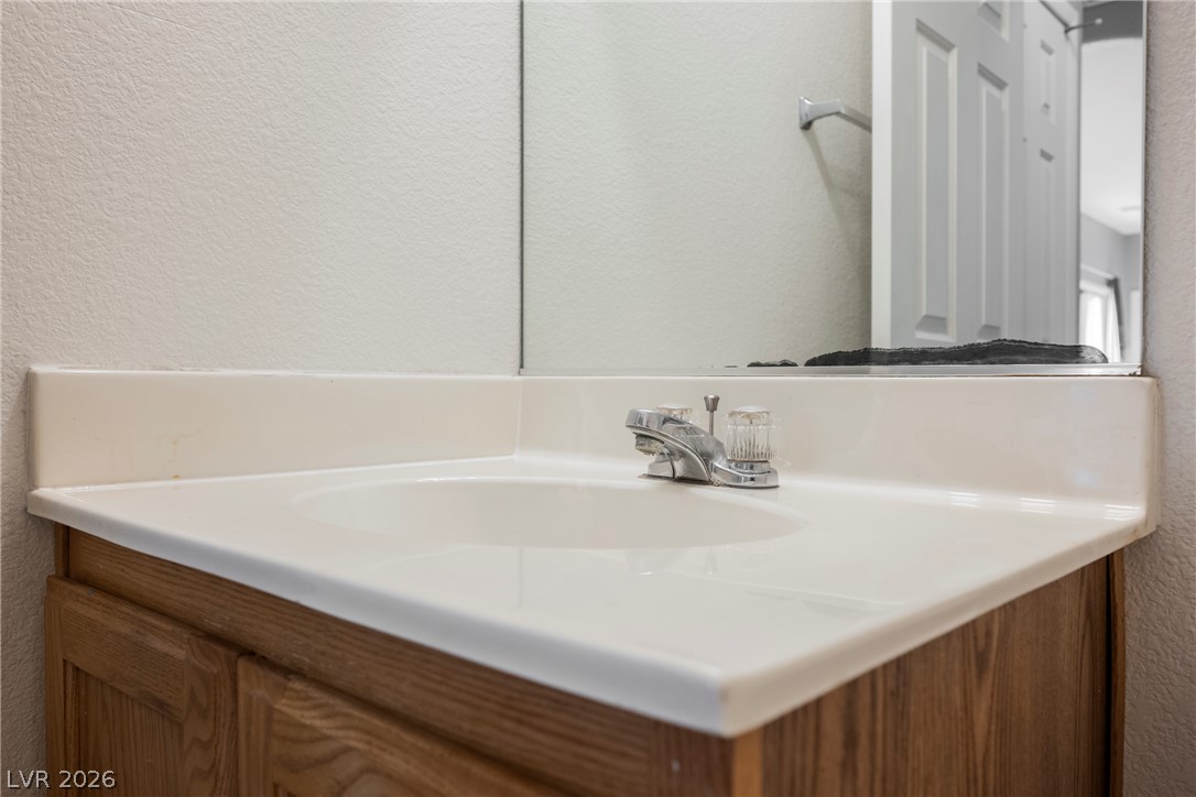 6320 Snap Ridge Street, Unit 201 North Las Vegas, NV 89081 - Photo 35 of 56 Functional vanity with a gleaming sink and reflective mirror.