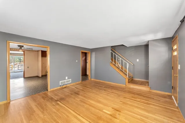 a view of a livingroom with wooden floor and a bedroom