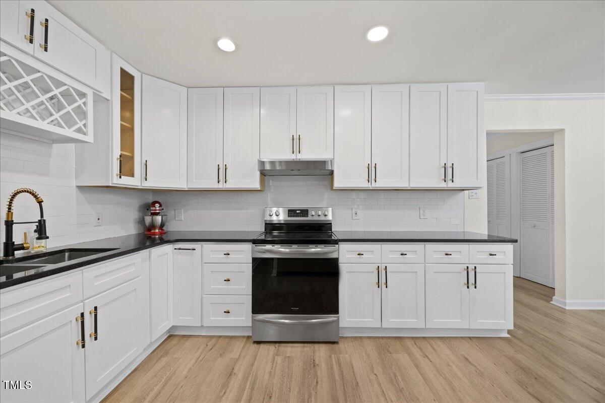 2013 Dartmouth Drive Durham, NC 27705 - Photo 10 of 32 a kitchen with stainless steel appliances granite countertop a stove a sink and white cabinets