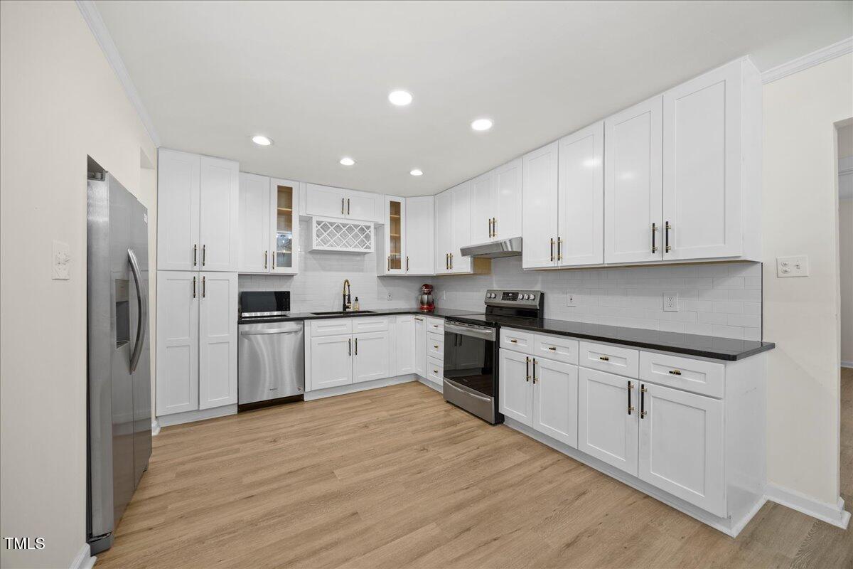 2013 Dartmouth Drive Durham, NC 27705 - Photo 11 of 32 a kitchen with granite countertop white cabinets and stainless steel appliances