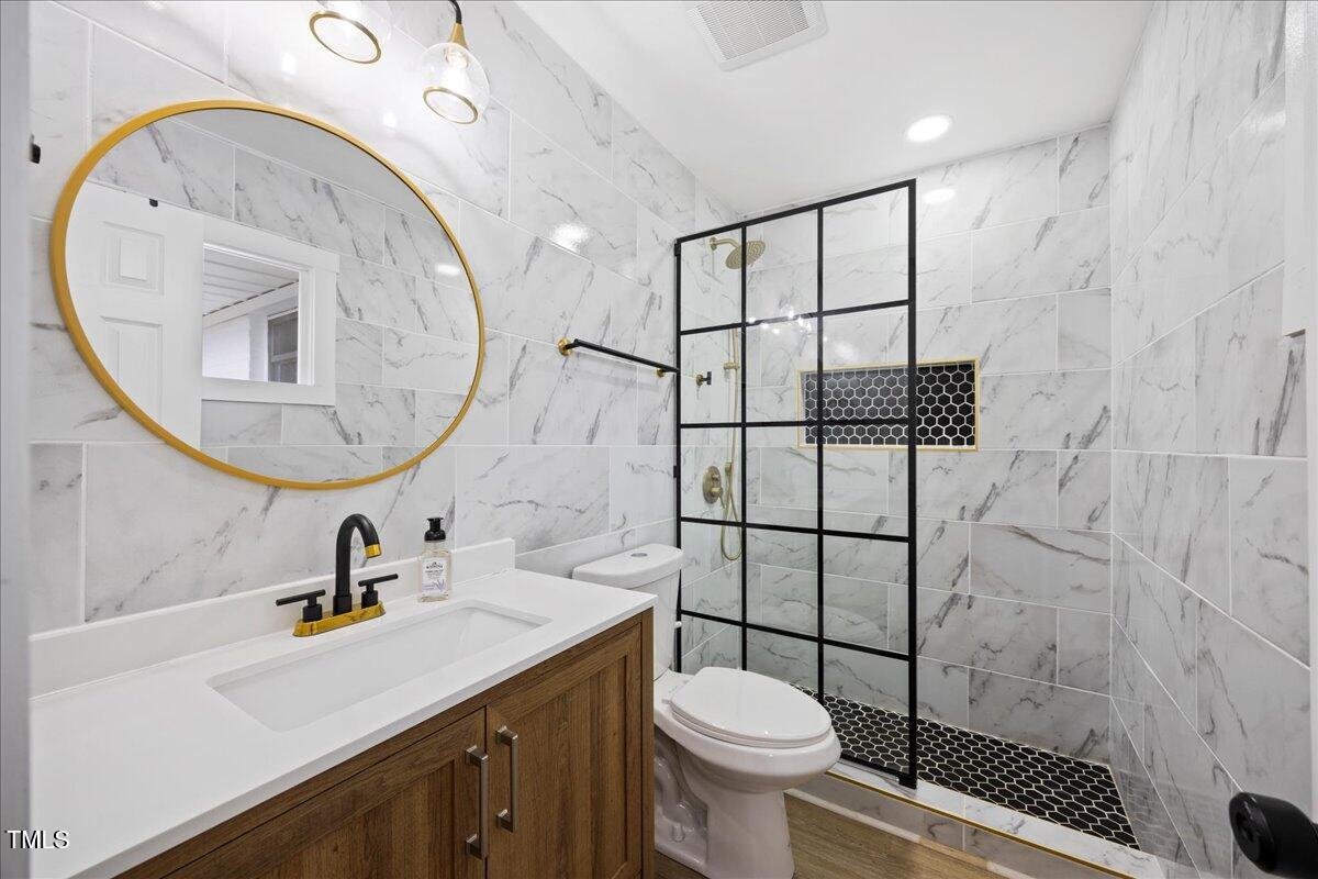 2013 Dartmouth Drive Durham, NC 27705 - Photo 17 of 32 a bathroom with a sink toilet a mirror and shower