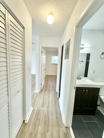 a view of a hallway with wooden floor and staircase