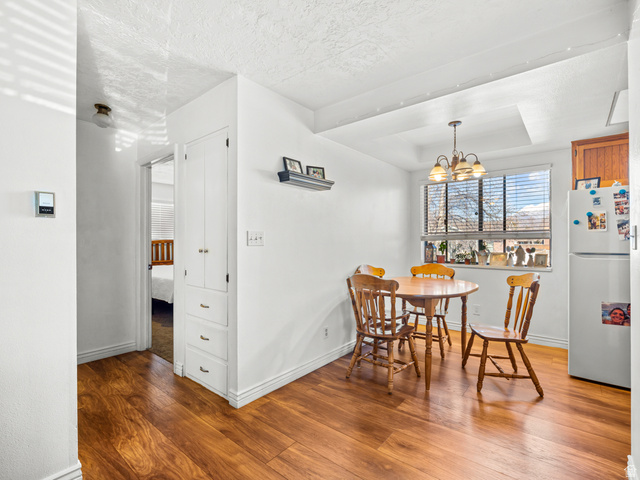460 200 South Provo, UT 84606 - Photo 37 of 66 Dining room with light wood-style floors, a chandelier, and a tray ceiling
