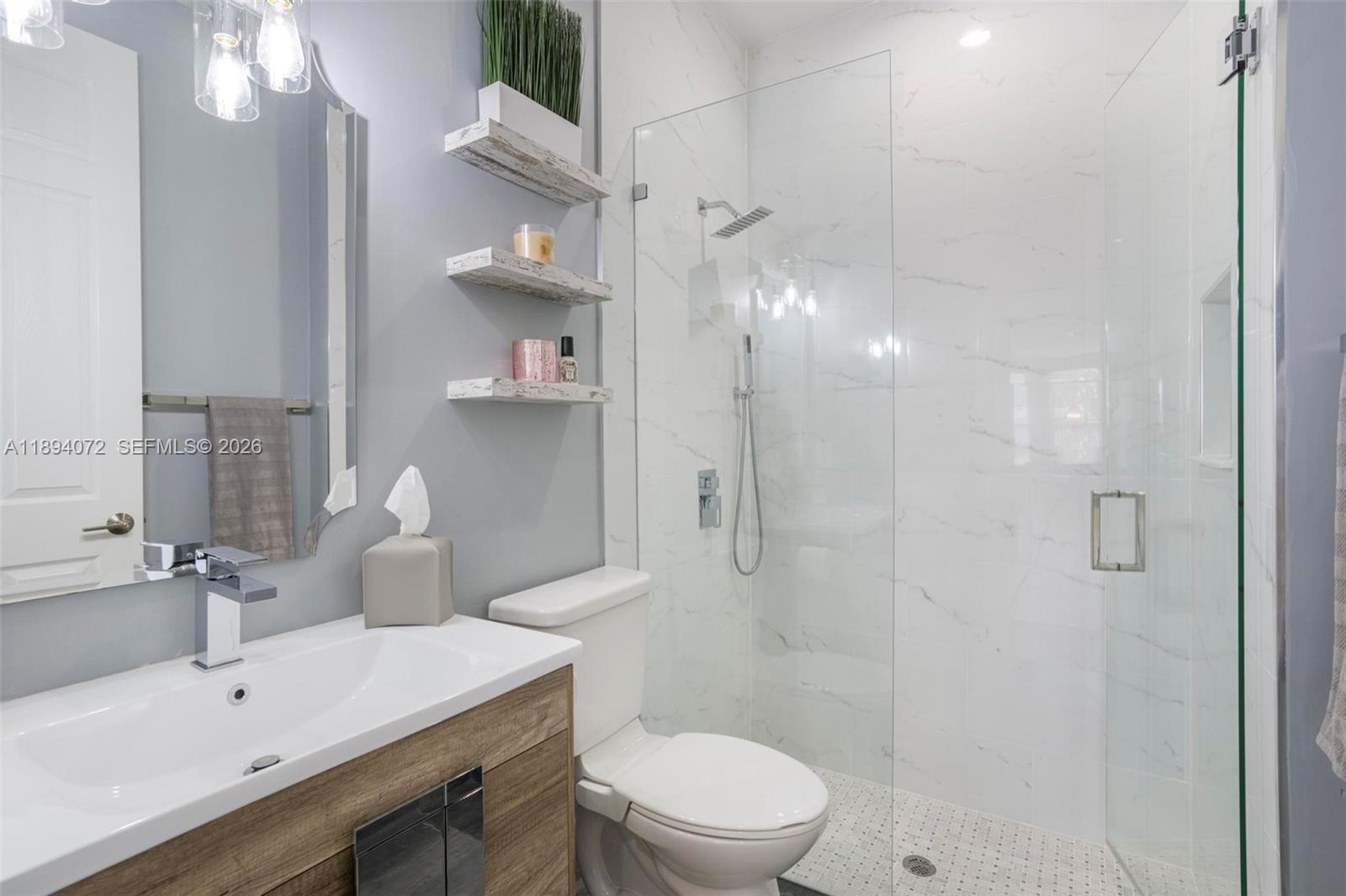 11750 Bayfield Drive Boca Raton, FL 33498 - Photo 23 of 52 a bathroom with a sink a toilet a mirror and shower