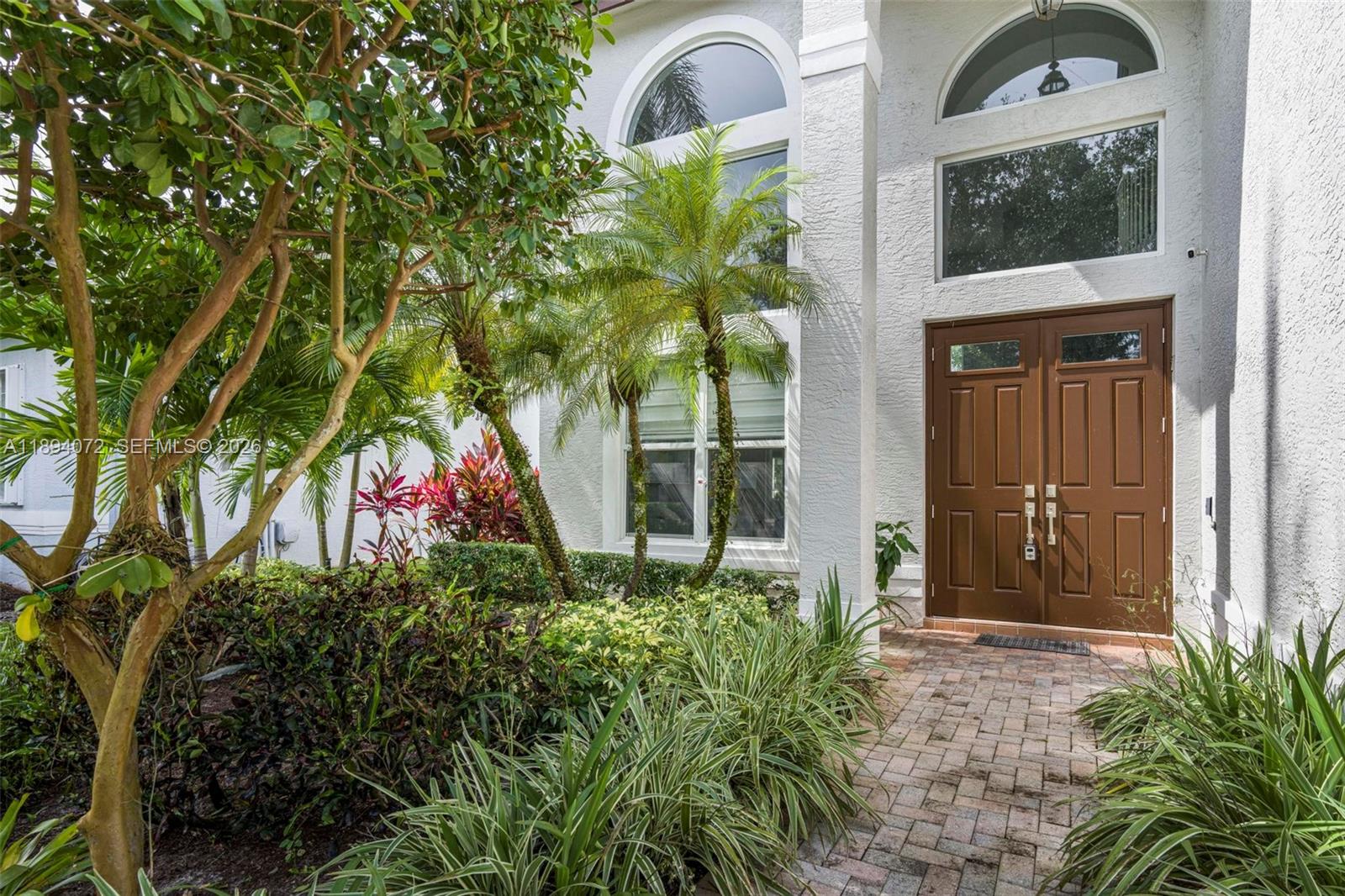 11750 Bayfield Drive Boca Raton, FL 33498 - Photo 5 of 52 a front view of a house with a yard